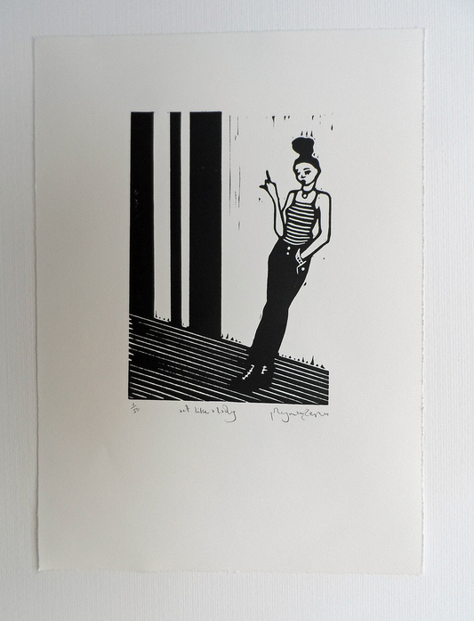 A black and white linocut artwork of a female figure with a bun standing on one foot, with a pointing finger, titled and signed by Polly Marix-Evans.
