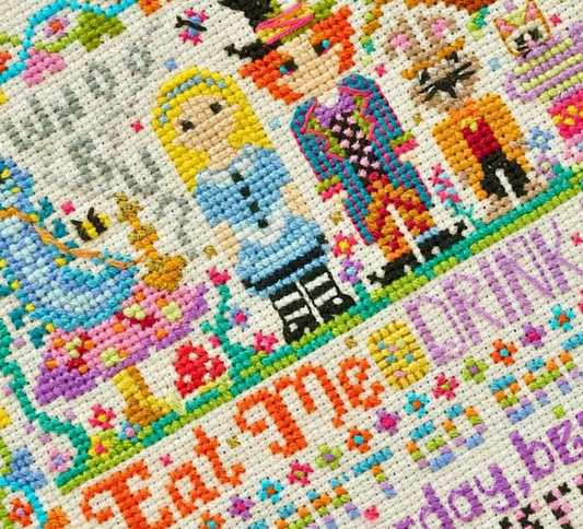 Colorful cross-stitched design with characters and text on a white background close up from an original cross stitch piece for Heart Gallery