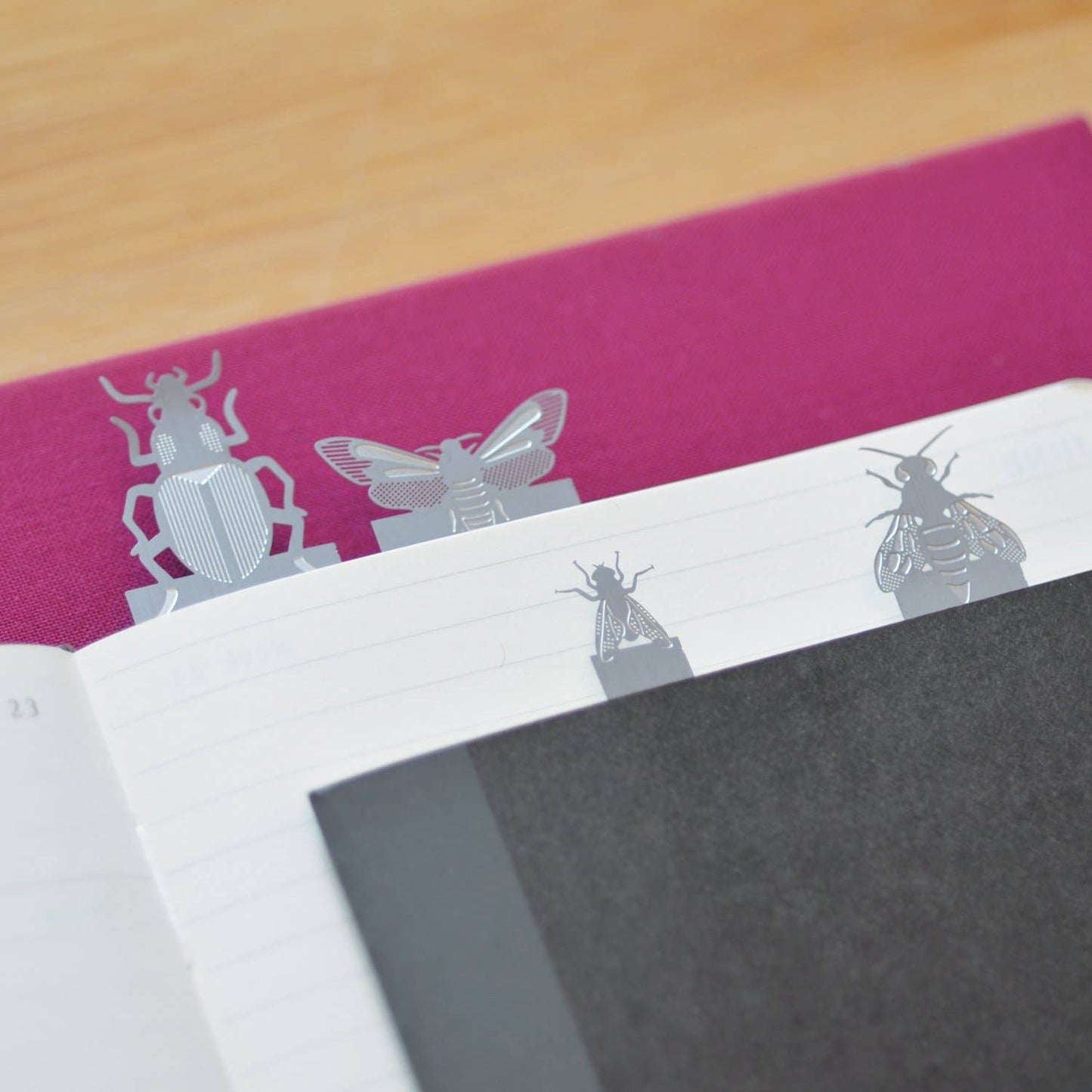 Insect page markers styoled by Another Studio attached to books and paper