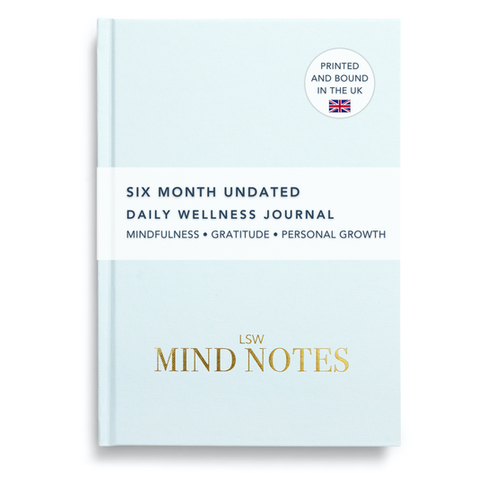 A light blue, undated daily wellness journal titled 'Mind Notes' with gold text, placed on a plain background.