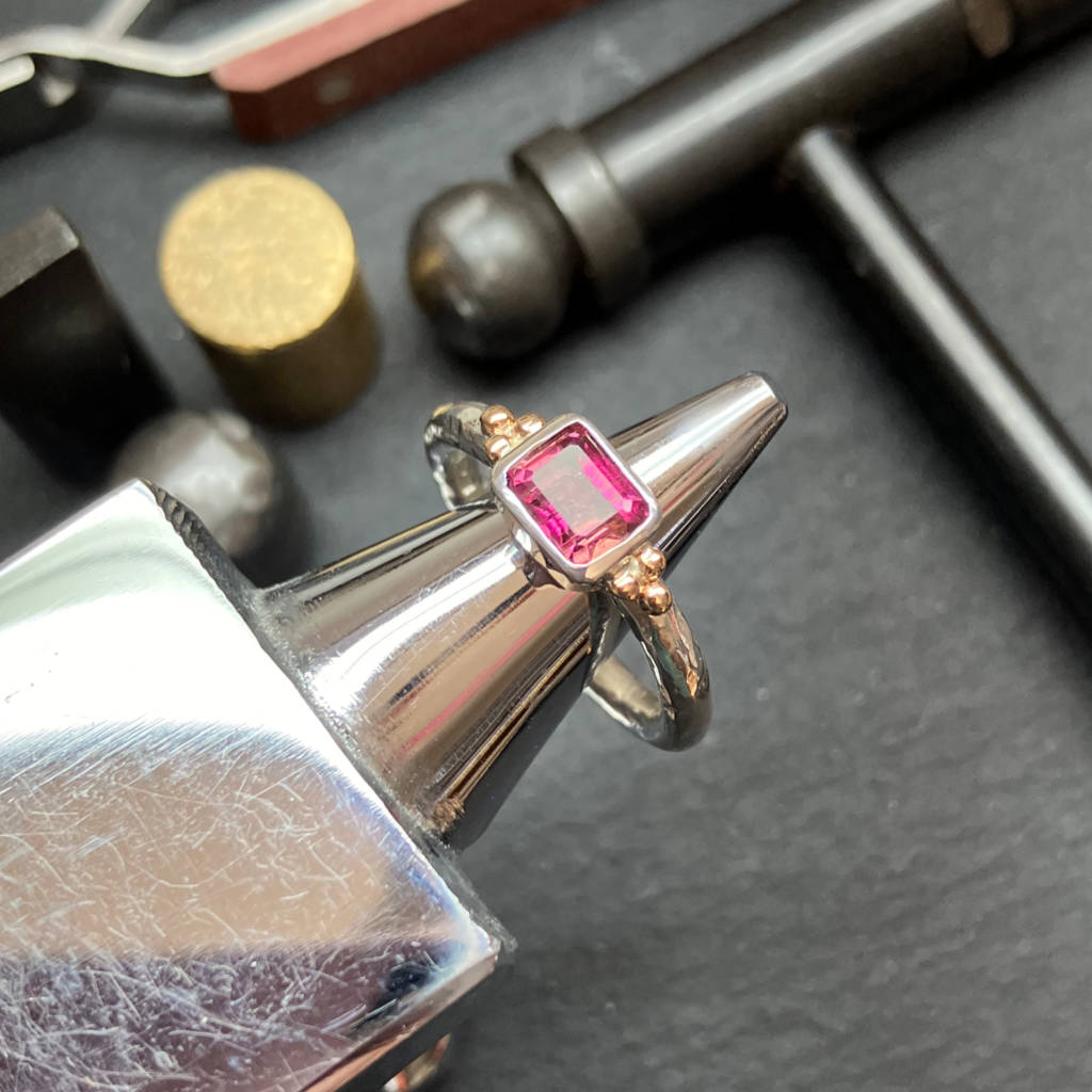 Amanda's workbench showing a silver and gold gemstone ring pink tourmaline