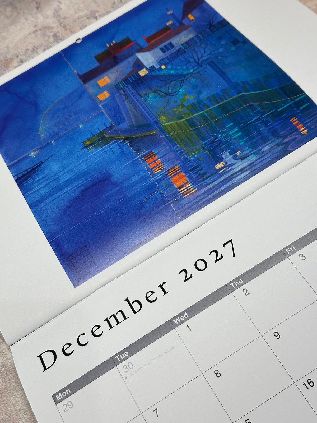 A close-up of a printed calendar page showing December 2027, with Staithes at Night above the date grid.
