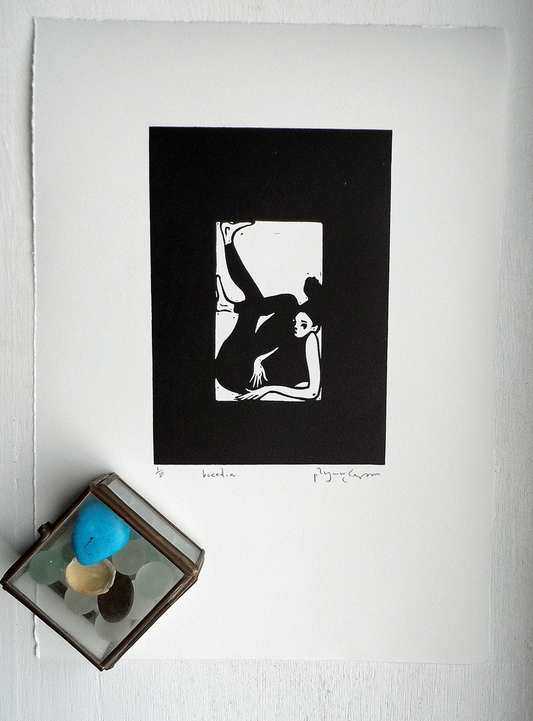 Original Linocut artwork by Polly Marix-Evans, a black and white print of a figure, titled and signed, presented on smooth white paper with a visible watermarked date. Accompanied by a colored glass object to the side.