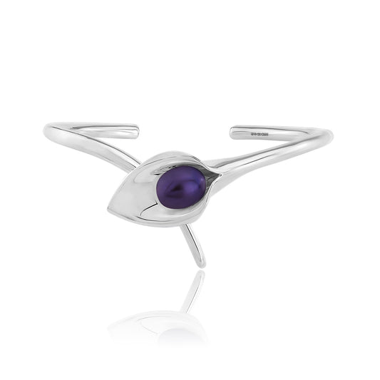 A silver bangle bracelet with a large cultured freshwater pearl, displayed against a white background.Amanda Cox, jewellery handmade in Hebden Bridge Yorkshire for Heart Gallery. Perfect Bridal Jewellery