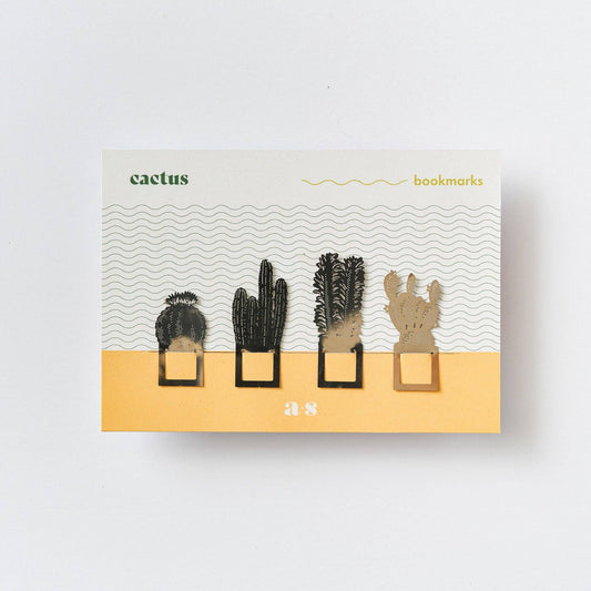 A set of four metal cactus-shaped bookmarks in silver colour, displayed in packaging with a desert-themed design and the brand name 'Another Studio'.