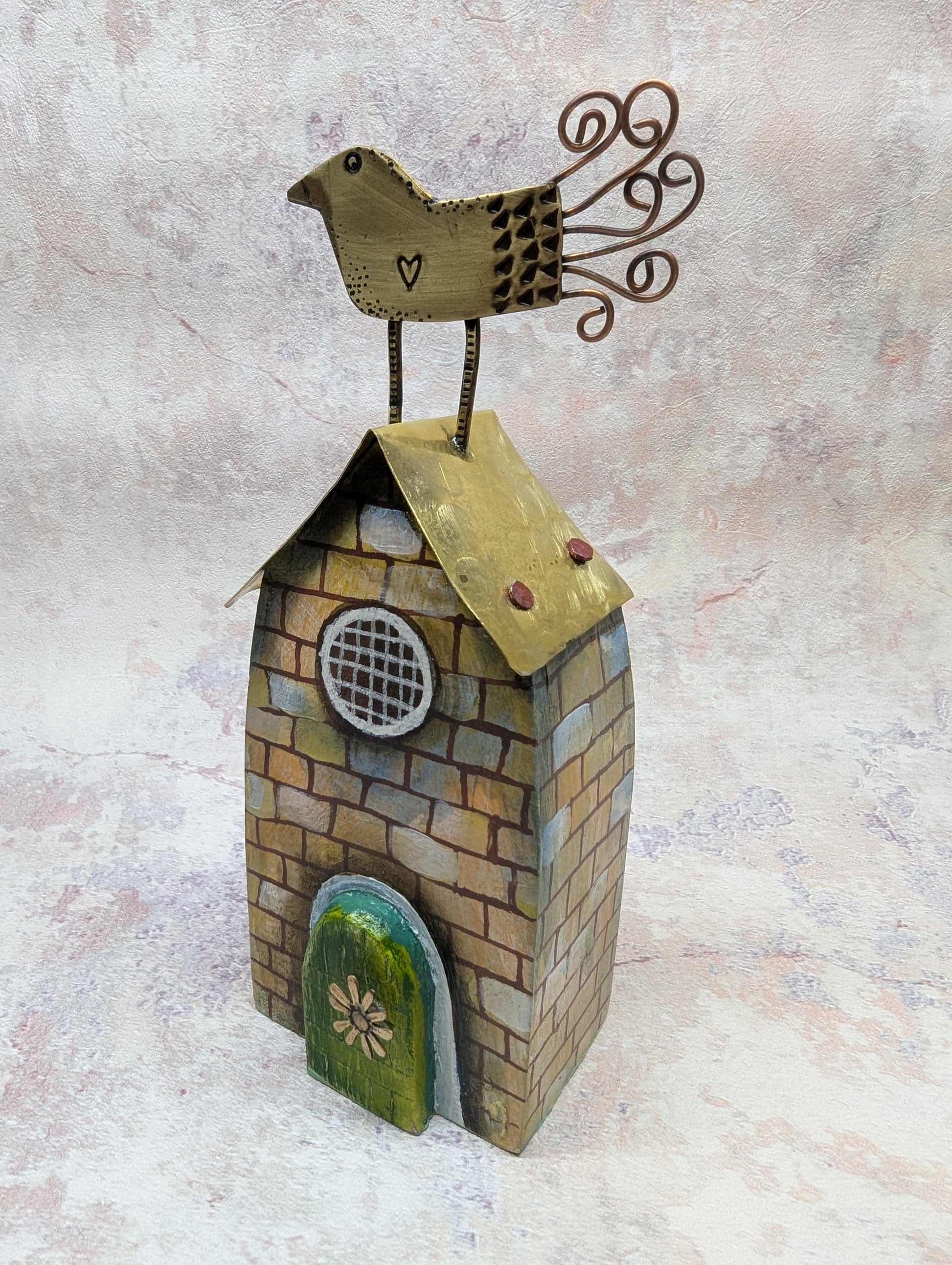 Decorative house with a bird on top against a textured beige background