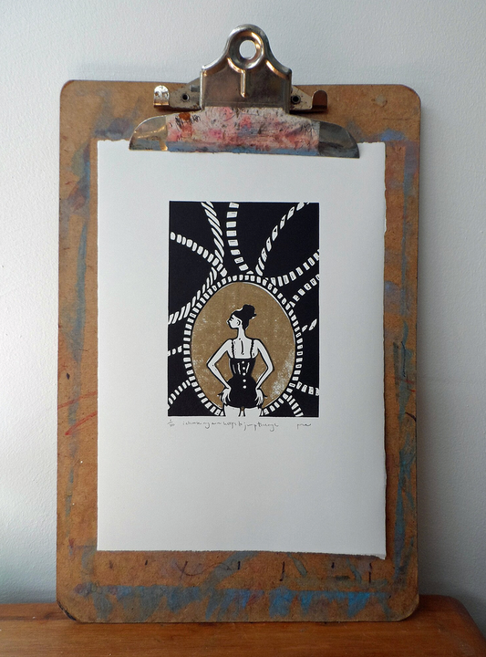 An originl linocut artwork depicting a figure with a hoop, displayed on a wooden clipboard by Polly Marix Evans