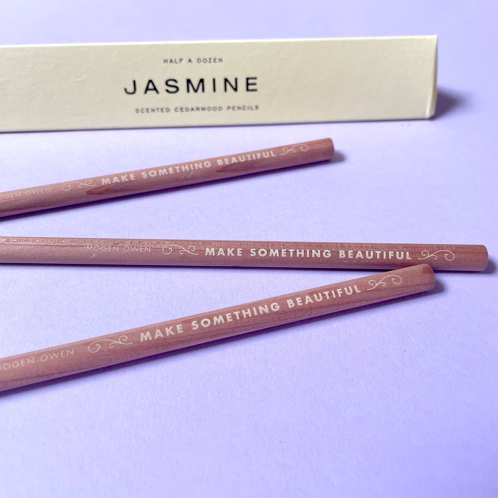 half a dozen scented cedarwood pencils with 'Make Something Beautiful' text on a purple background, accompanied by a letterpress box labeled 'Jasmine'  by Imogen Owen for Heart Gallery