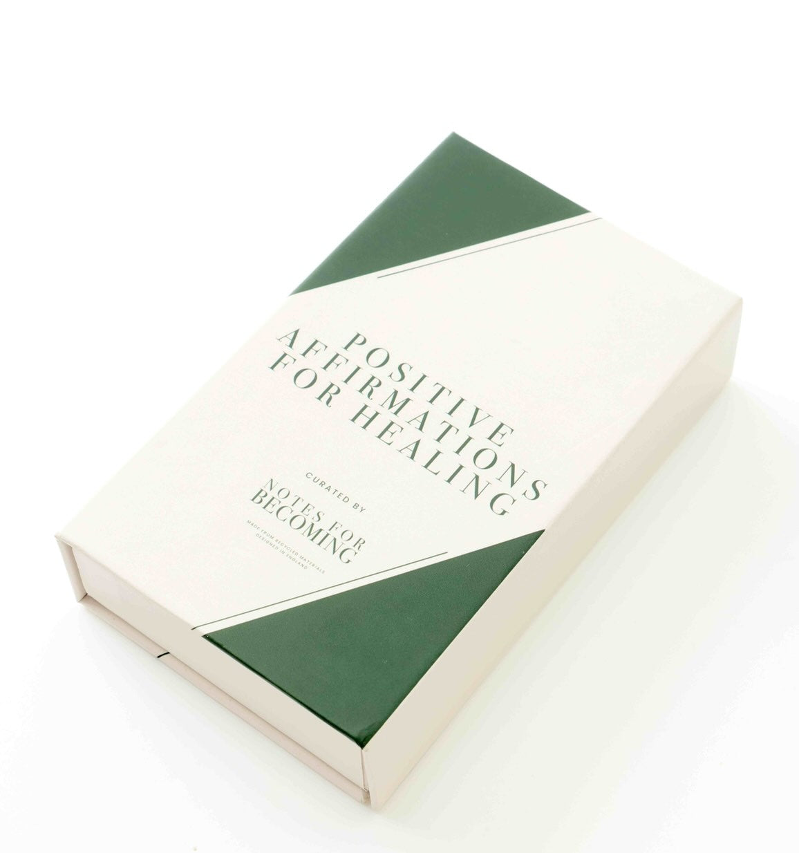 A boxed book or journal titled 'Positive Affirmations for Healing' with a cream cover and dark green geometric accents, photographed on a clean white background.
