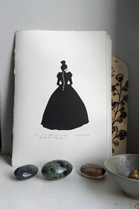 A signed and titled original linocut print by Polly Marix-Evans, depicting a silhouette of a woman in a dress, displayed on a white piece of paper with some decorative objects around it.