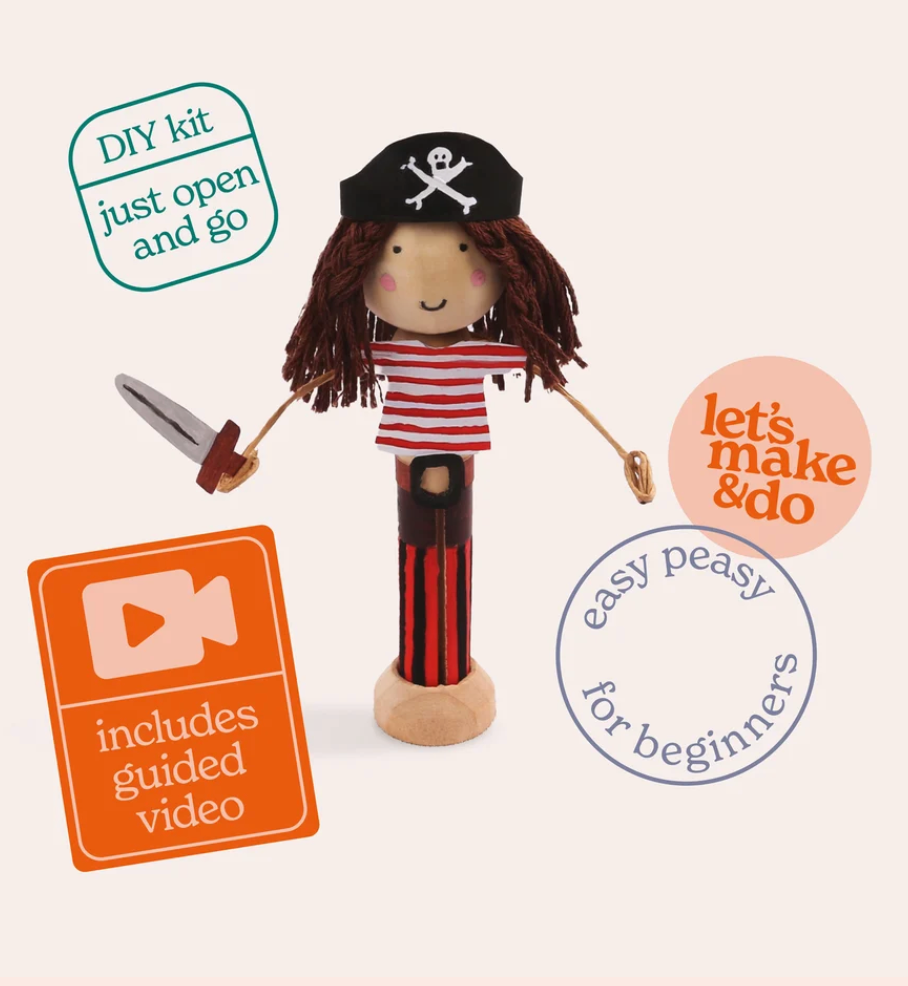 A pirate-themed DIY wooden toy kit shown on a light cream background with promotional badges. The main product is a wooden pirate figure with a black hat, red-and-white striped shirt, dark red pants, and brown yarn hair, holding a silver sword.