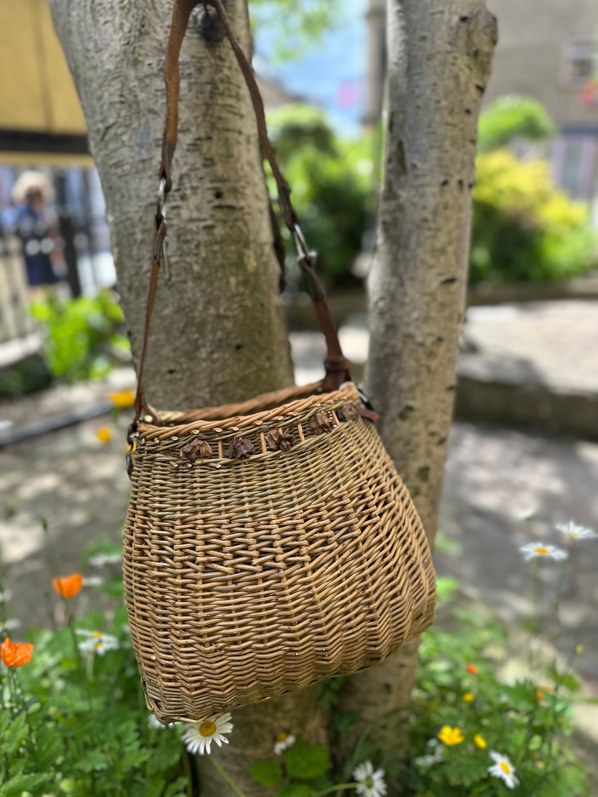 Woven bag hanging on a tree with a blurred outdoor background
