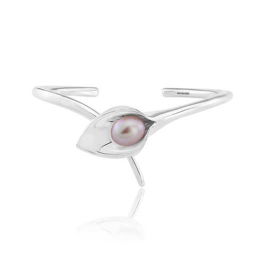 A silver bangle bracelet with a large cultured freshwater pearl, displayed against a white background.Amanda Cox, jewellery handmade in Hebden Bridge Yorkshire for Heart Gallery. Perfect Bridal Jewellery