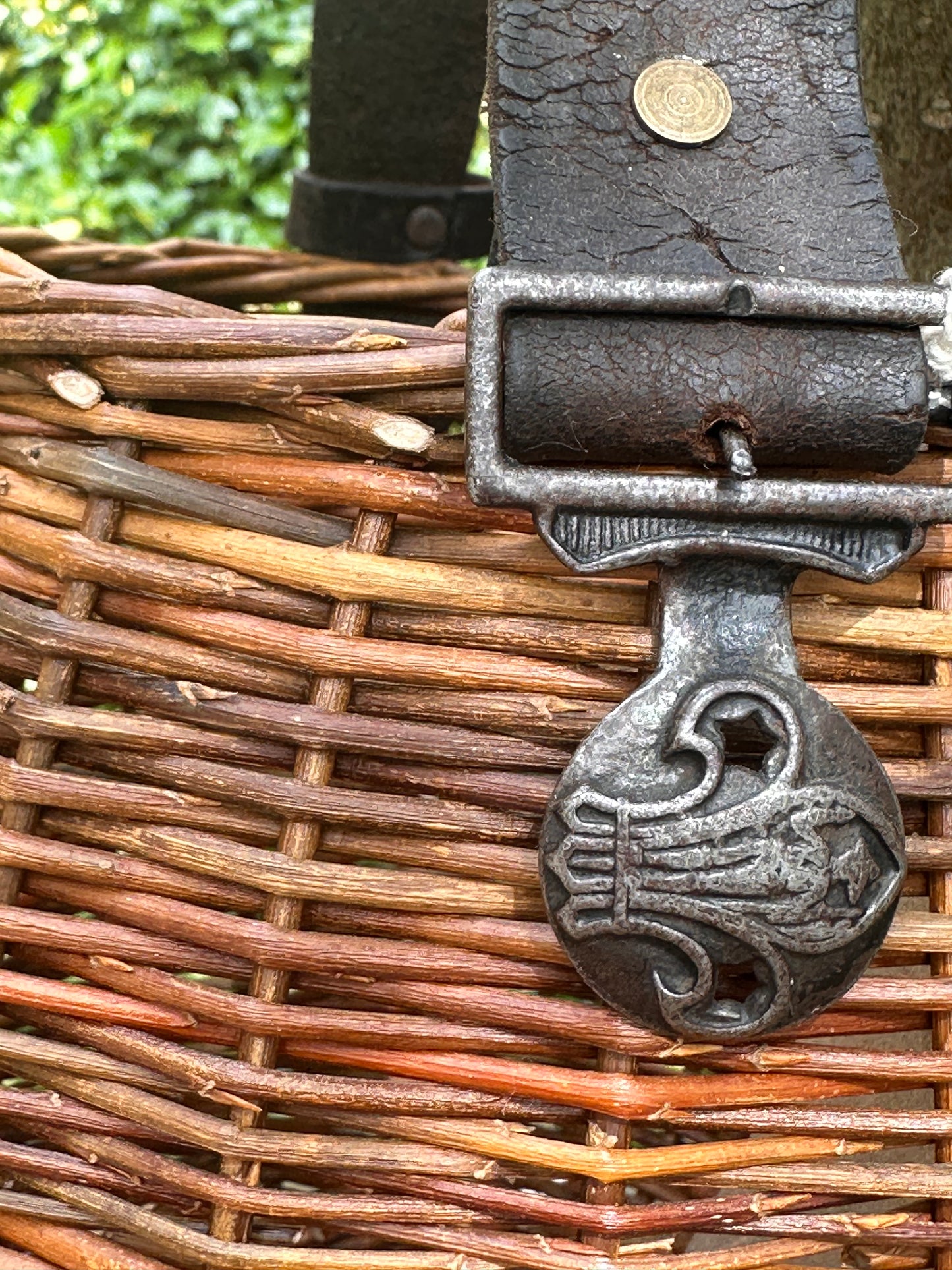 Close-up of a metal clasp on a woven basket with a coin on top