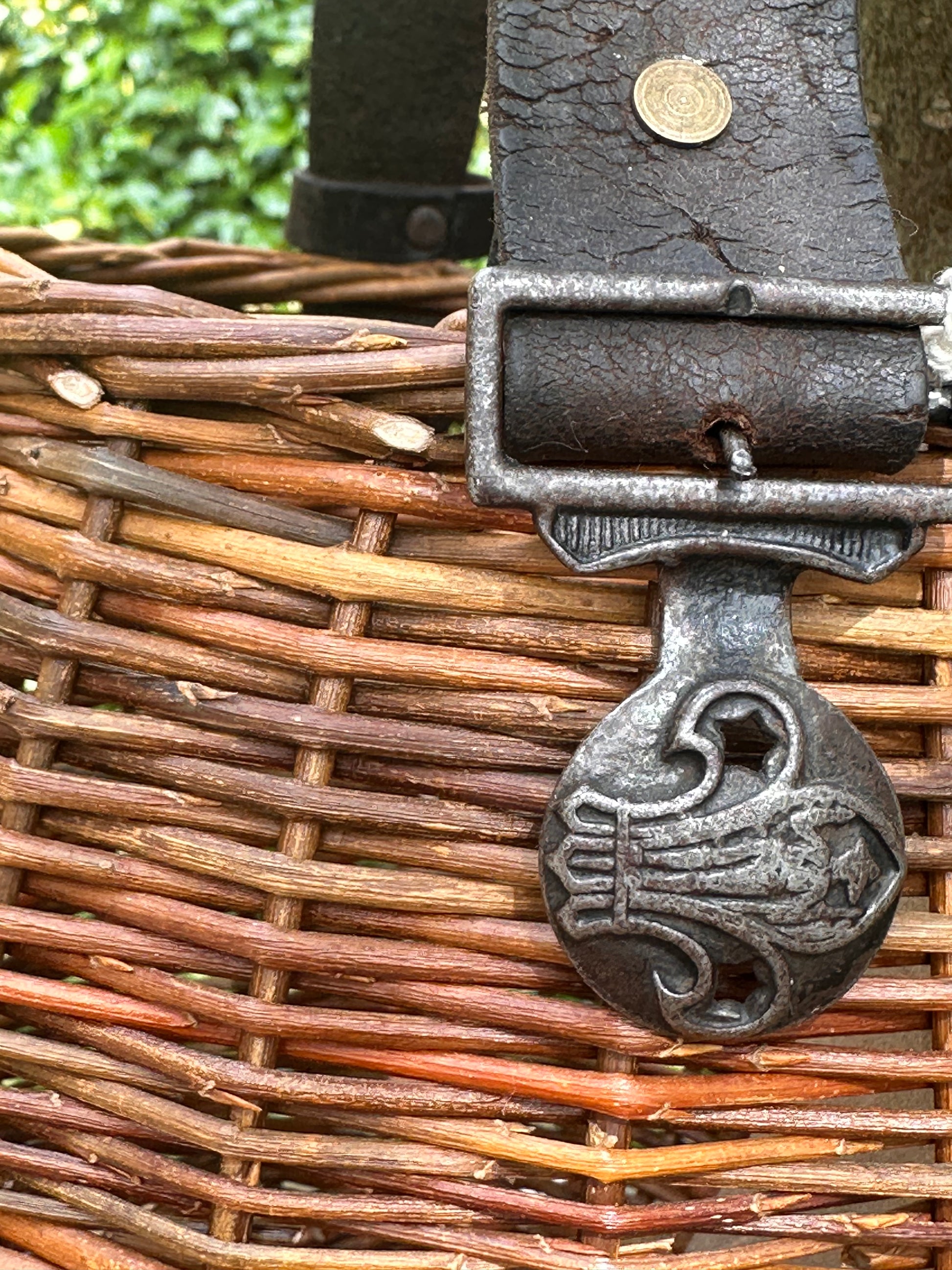 Close-up of a metal clasp on a woven basket with a coin on top