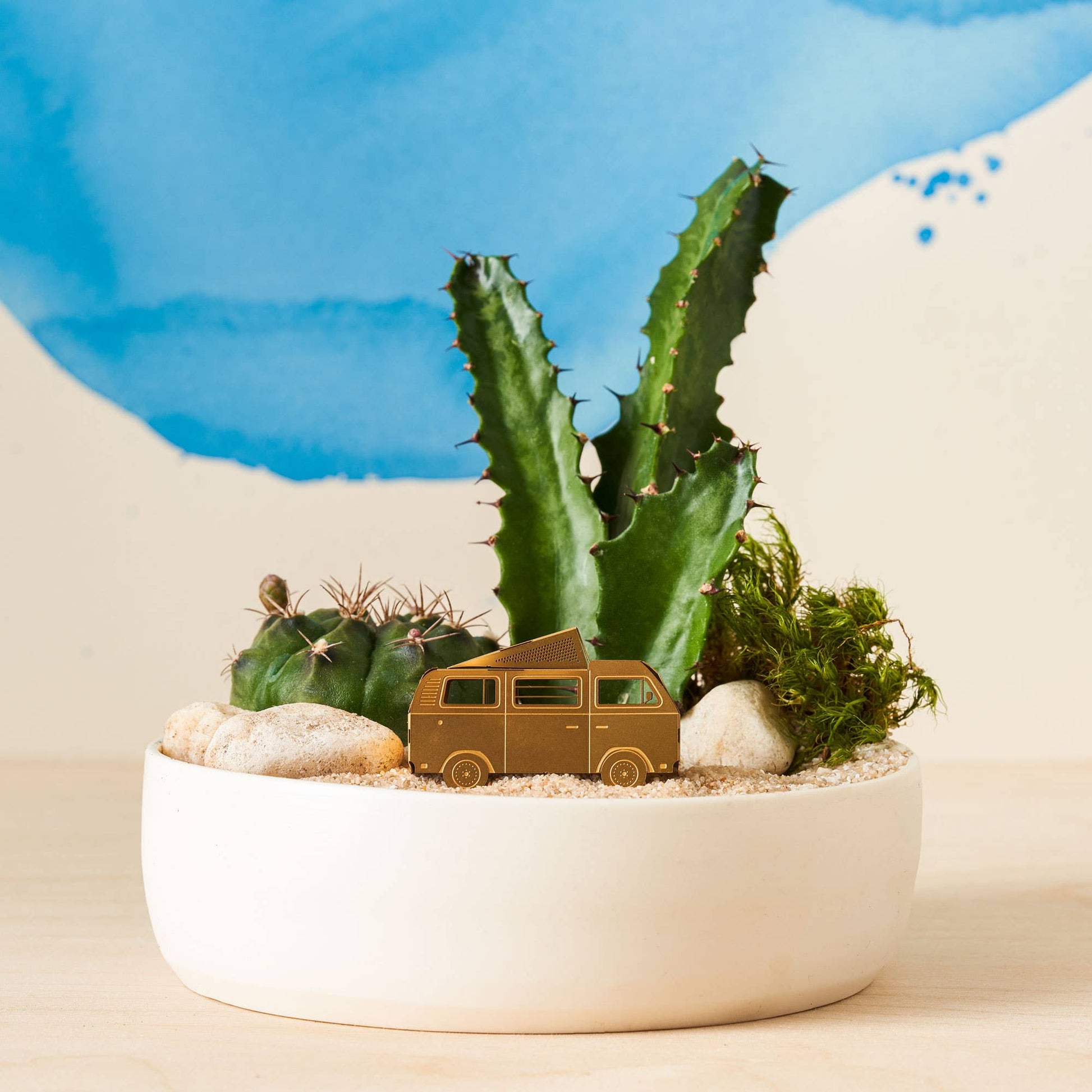  A brass miniature model of a camper van with a pop-top roof, shown as a terrarium or plant decoration by Another Studio