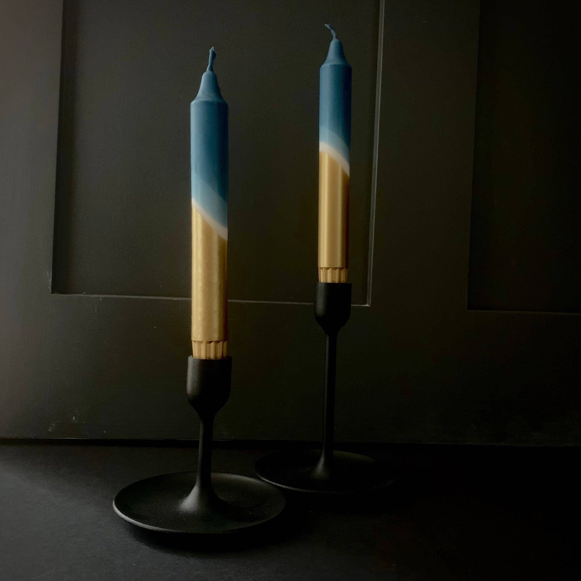 Styled teal blue and gold candles by The Stining Rabbit on a dark moody background