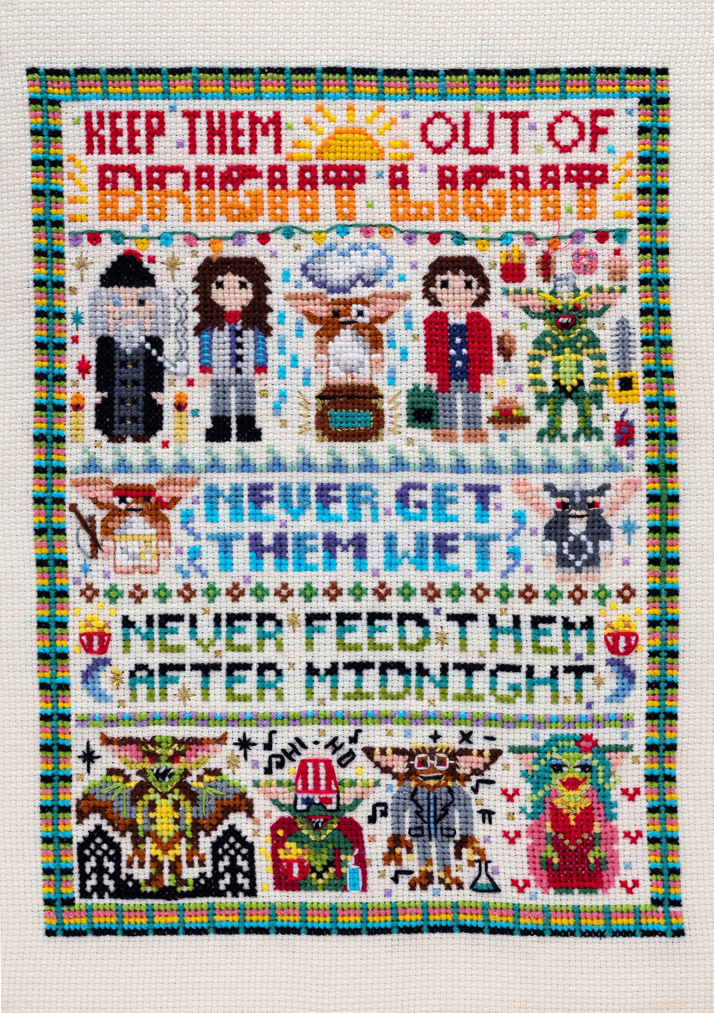 Cross-stitched pattern with characters and text on a white background inspired by dark comedy The Gremlins