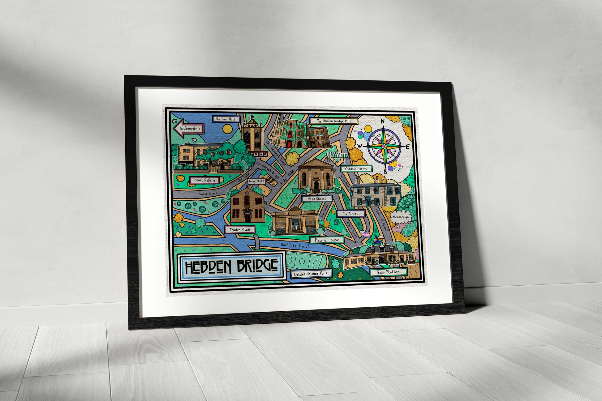 Framed colorful map of Hebden Bridgon a white wall 