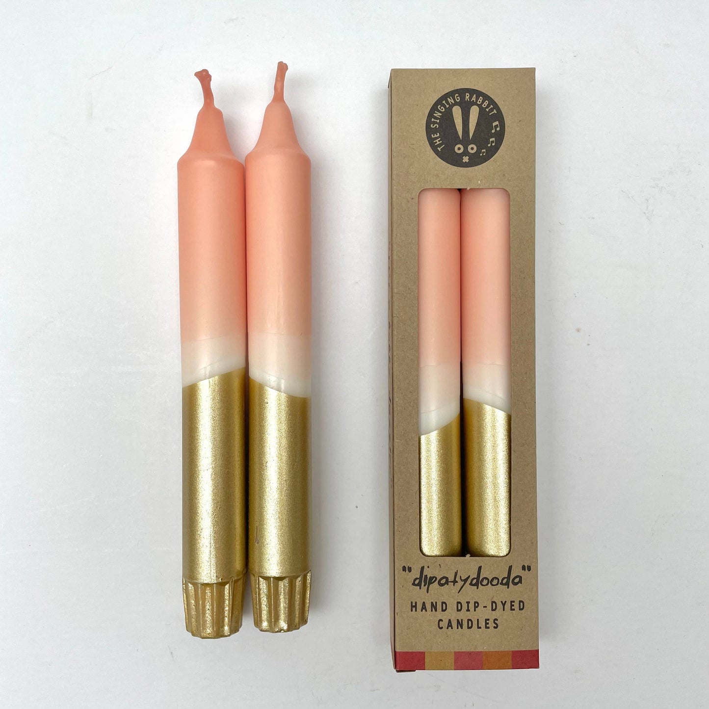 Two dinner candles with a blush pink and gold color scheme packed in eco packaging by The Singing Rabbit for Heart Gallery