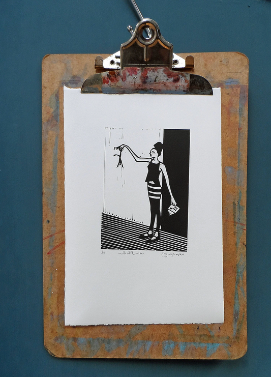 A signed and titled original linocut by Polly Marix-Evans mounted on a clipboard, depicting a black and white print of a person reaching upwards holding a small male