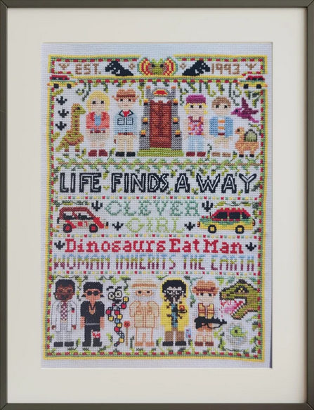 Framed cross-stitched artwork with various characters and text by Helen Bretherton for Heart Gallery