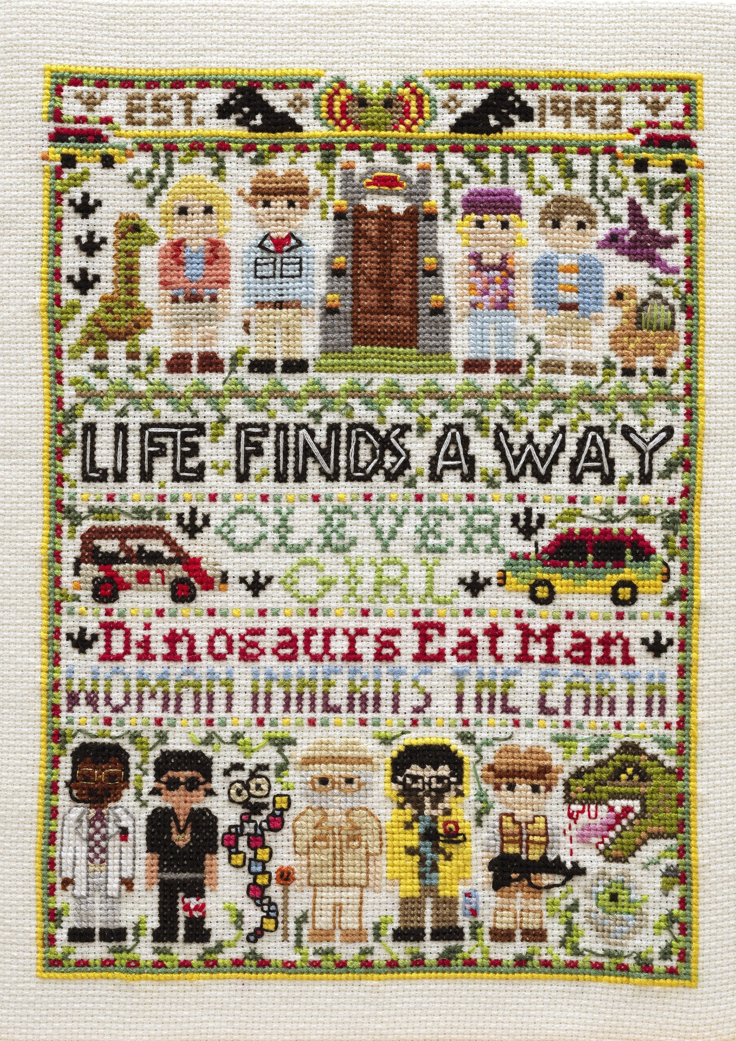 Cross-stitched design with characters and text on a white background