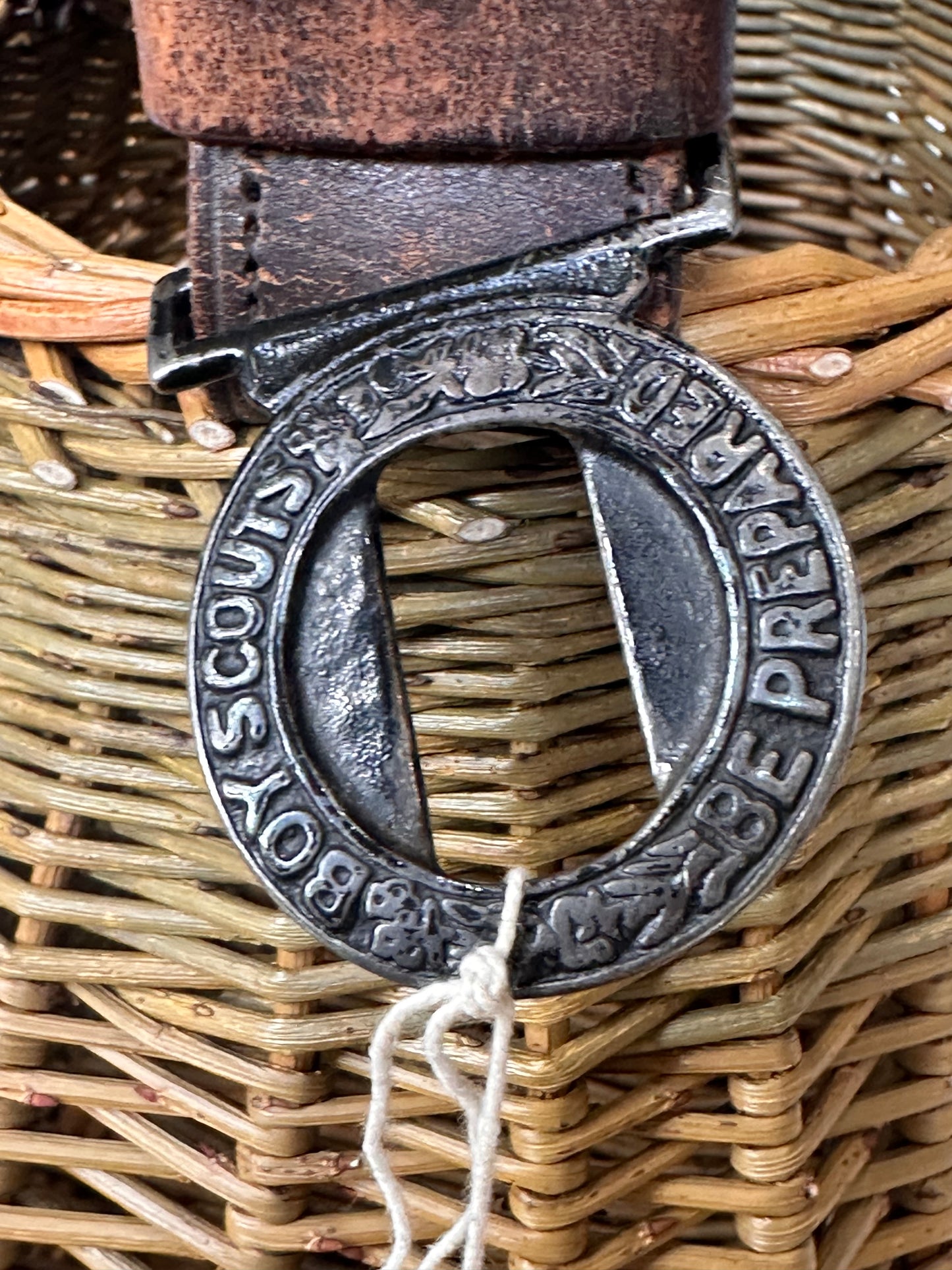 Close-up of a Boy Scout belt buckle on a woven background