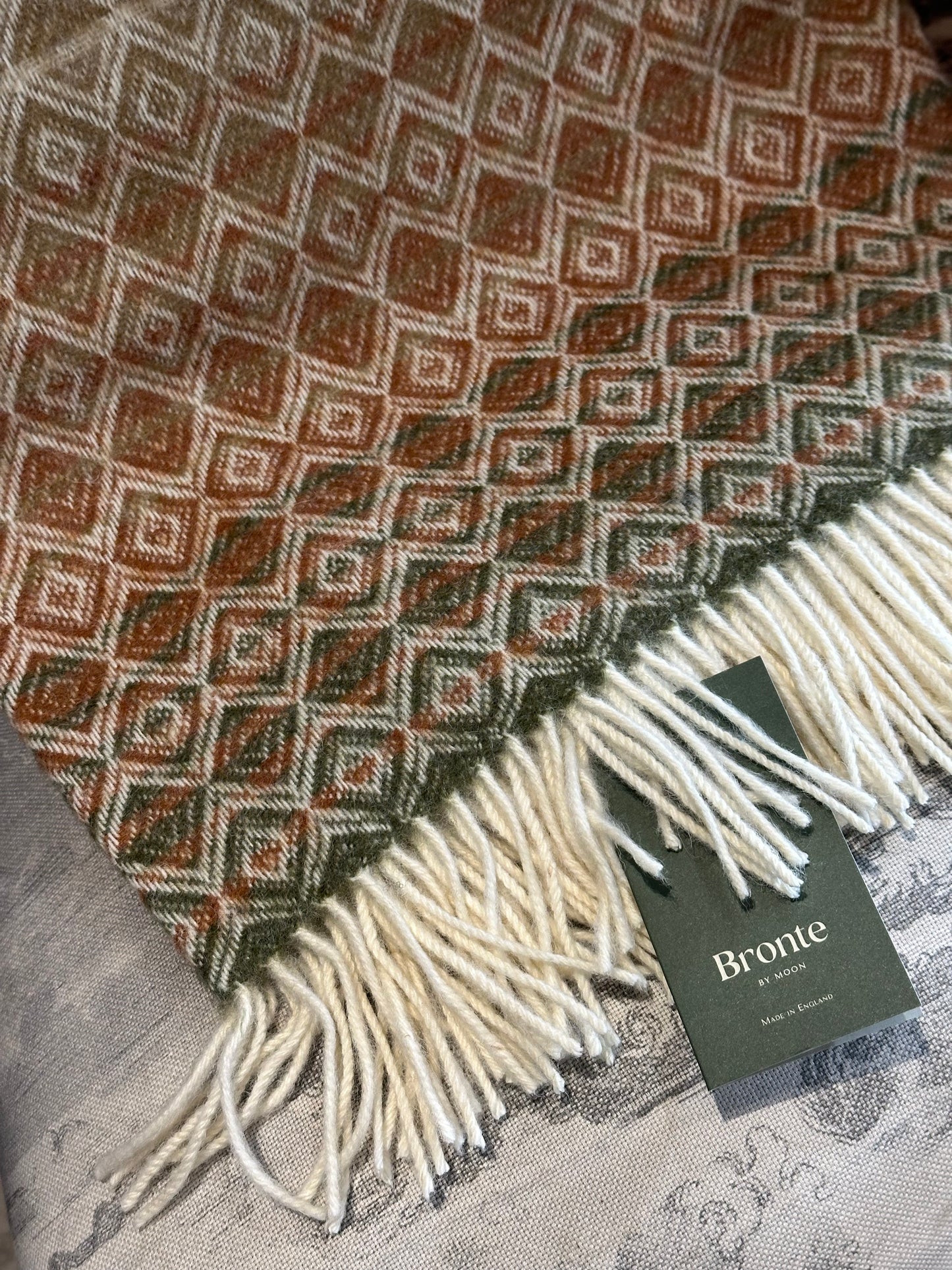 close up of Bronte Moon ombre throw in terracotta and green
