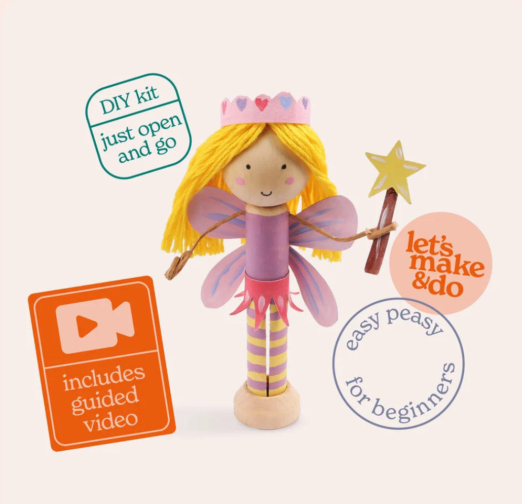 A wooden fairy DIY craft kit with a wooden doll featuring yellow hair, purple wings, a pink crown, and a star wand, shown on a light beige background with promotional badges.